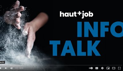 Zwei Hände, die durch aufgewirbeltes Pulver bewegt werden, mit dem Text "haut+job INFO TALK" auf schwarzem Hintergrund.